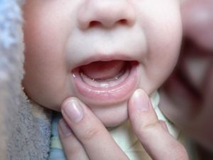 Во сколько режутся первые зубки у детей